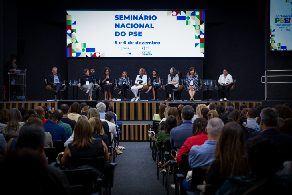 mesa composta por 10 pessoas, com uma plateia